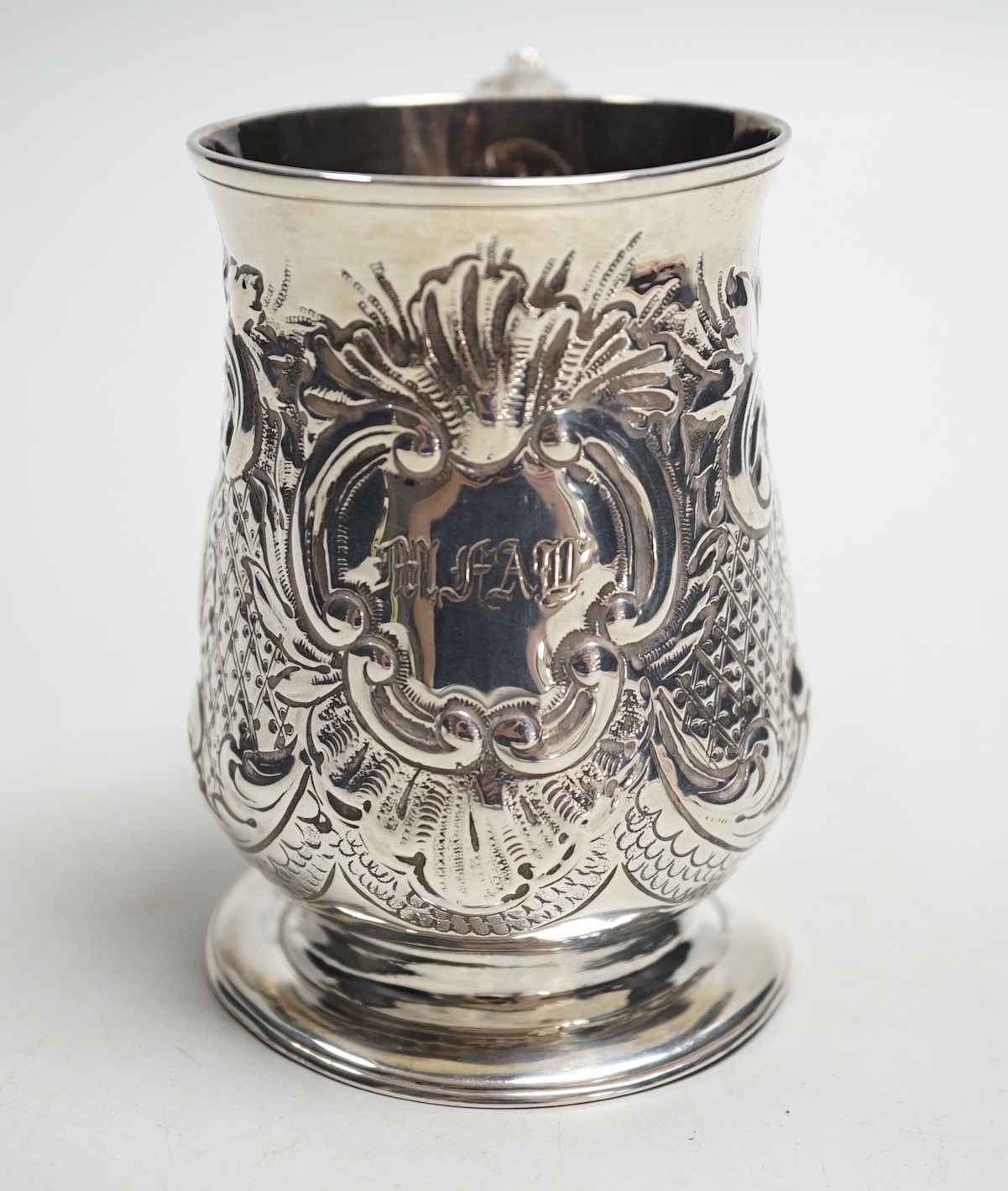 A George III silver baluster mug, with later embossed decoration, John King, London, 1775, height 93mm, 5.2oz.